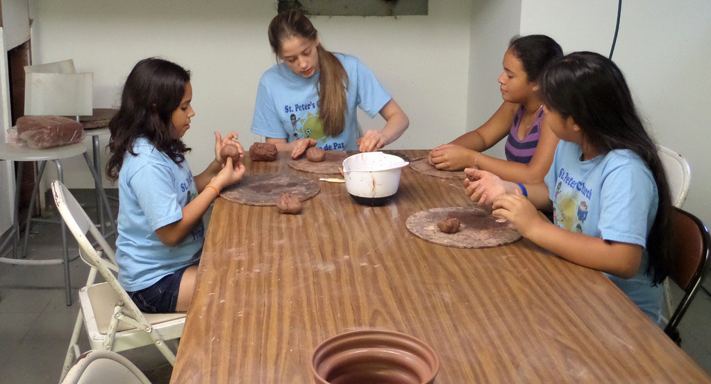 Hannah Kraft helps students at St. Peter’s bilingual vacation Bible camp.