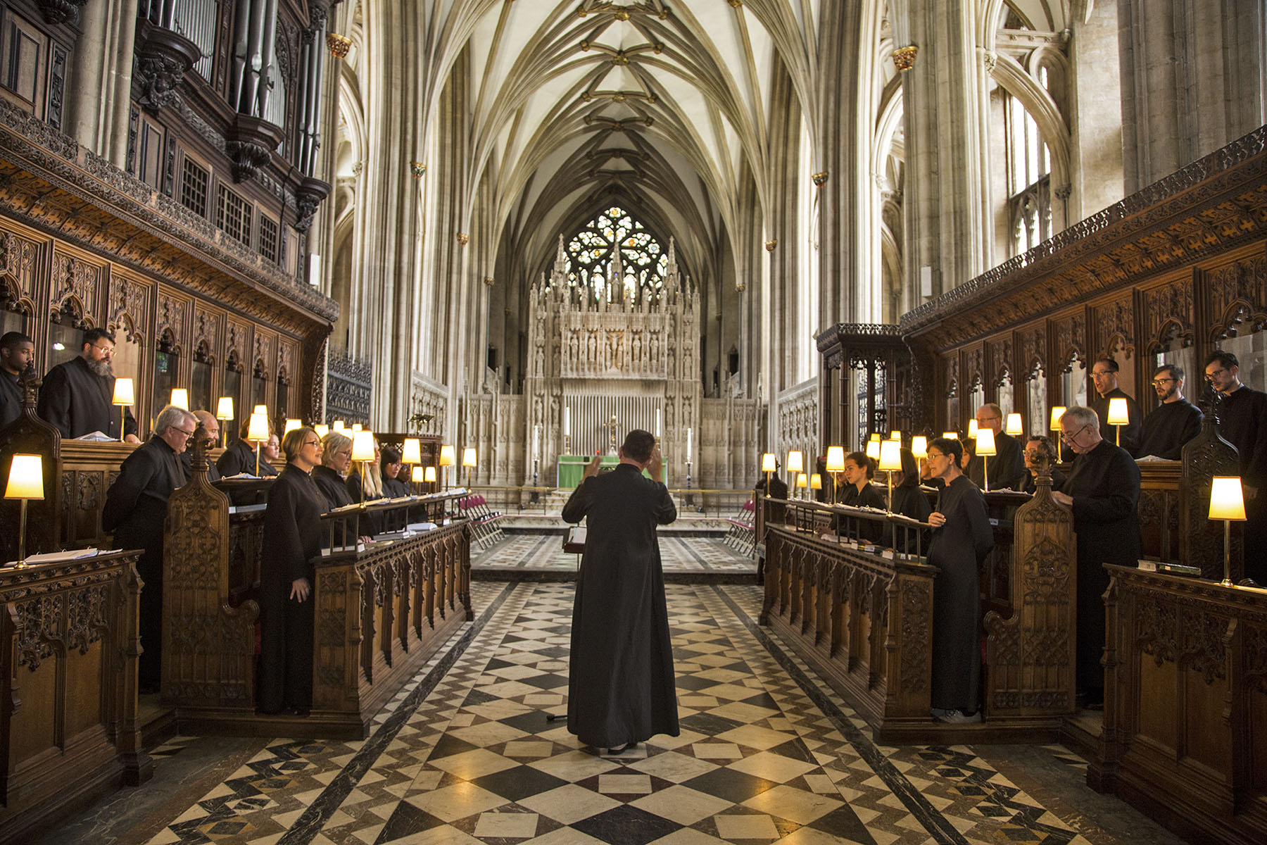 Organist-Choirmaster, Dr. Andrew Moore, conducting the choir during Evensong at Bristol Cathedral.