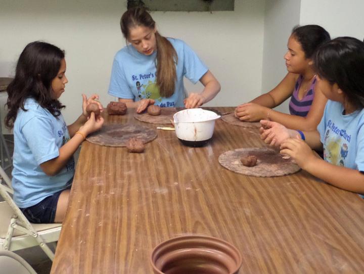 Hannah Kraft helps students at St. Peter’s bilingual vacation Bible camp.