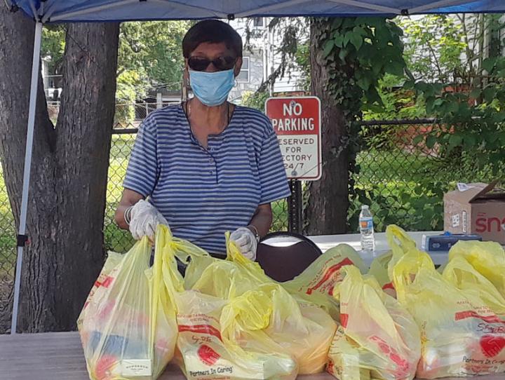 Volunteer Joyce Ifill staffs a table at the Epiphany and Christ Church, Orange food pantry on June 20. GERALDINE STEMPER PHOTO