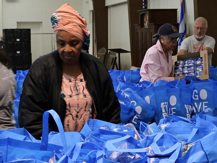 Volunteers packing some of the hundreds of bags of food that will be distributed at St. Paul's, Englewood. NINA NICHOLSON PHOTO