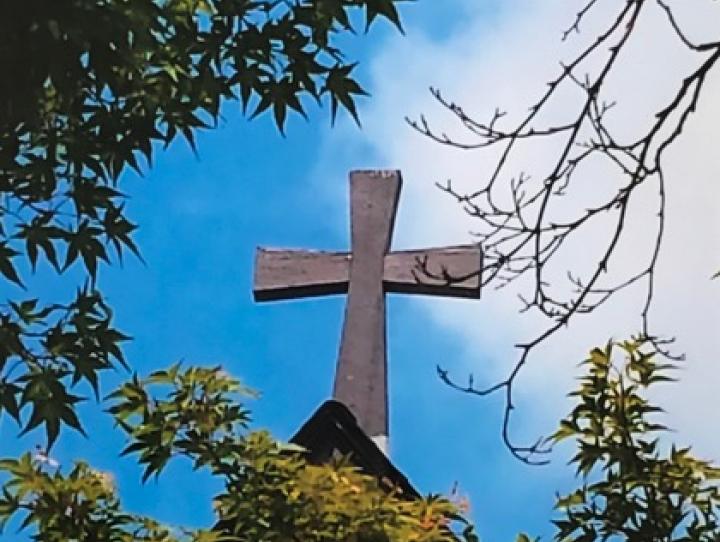 Picture of a cross against a blue morning sky