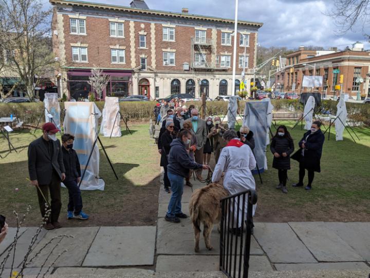 The donkey-led Palm Sunday procession arrives at the steps of St. James, Upper Montclair. Shrouded, tombstone-like Stations of the Cross created from doors await their unveiling after the service. FRAN LAPINSKI PHOTO