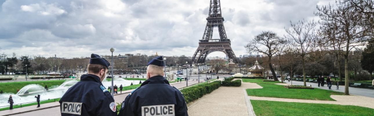 French police patrol the gardens surrounding the Eiffel Tower.