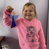 Colleen Hintz’s youngest granddaughter with the angel sun catcher she created. Hintz has taught each of her grandchildren how to create with stained glass.