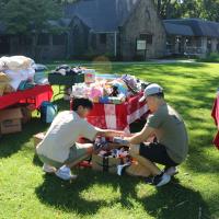 High school volunteers Kyle and Ethan set up the flea market of gently used items.