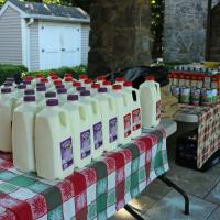 Milk and pantry goods set up on tables in the shade.