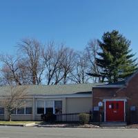 A panoramic view of the St. Peter's campus. The church is flanked by connected office and classroom space on the left, and a separate rectory on the right.