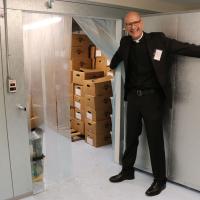 The Rev. John Mennell shows off the new walk-in refrigerator. Next to it is a walk-in freezer.