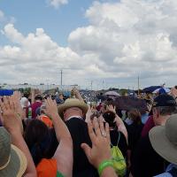 Around 1000 people came to the Episcopal witness outside the Hutto Detention Center today. In this panoramic photo, the assembly is facing the detention center with their hands raised in prayer. We later found out the women detained there were "glued to the windows until the last bus left." NINA NICHOLSON PHOTO
