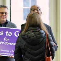 Canon Gregory Jacobs and Randy Johnson offer Ashes to Go in the pedestrian walkway from Newark Penn Station to Gateway Center. NINA NICHOLSON PHOTO