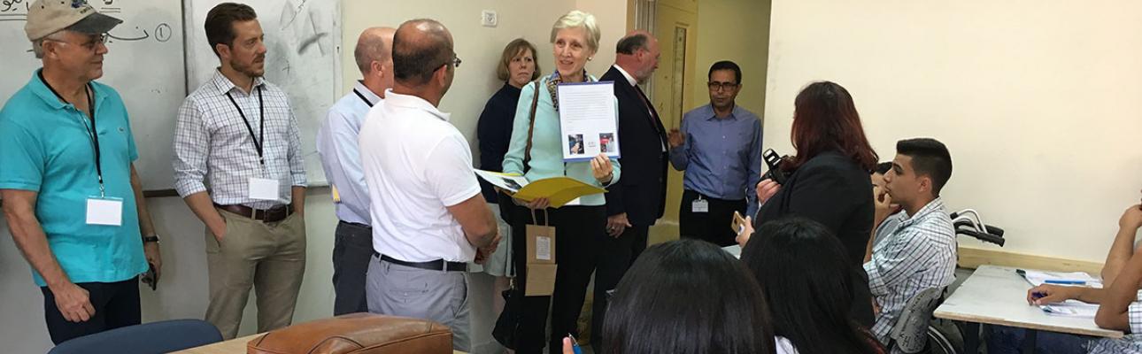 Barbara Boehm, center, a parishioner from St. James Episcopal Church in Montclair, New Jersey, presents a letter from student employees at the church’s thrift shop to children at the Jerusalem Princess Basma Centre in 2018. PHOTO COURTESY AFEDJ