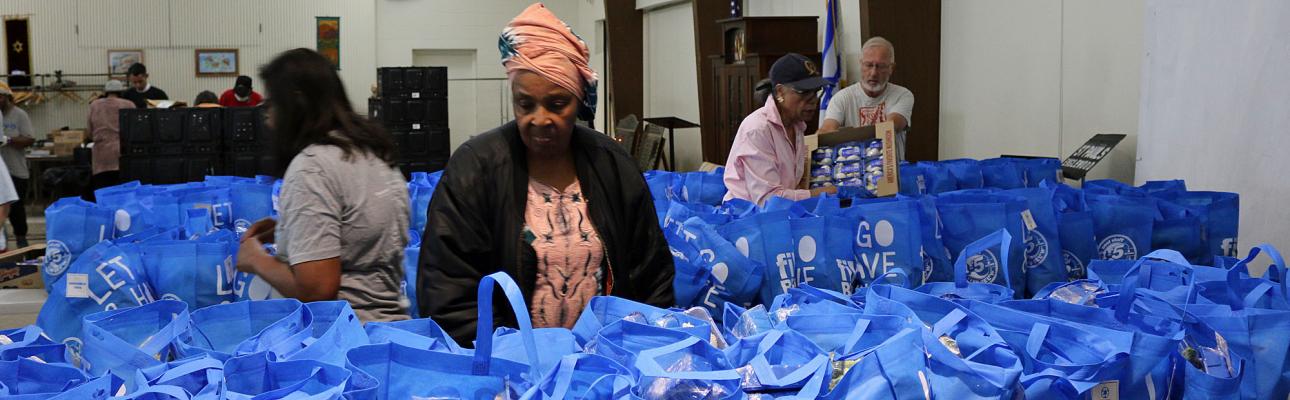 Volunteers packing some of the hundreds of bags of food that will be distributed at St. Paul's, Englewood. NINA NICHOLSON PHOTO