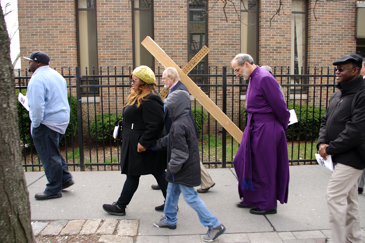 Casper Ewig of St. Paul's in Bergen carries the cross as Bishop Mark Beckwith and others follow.